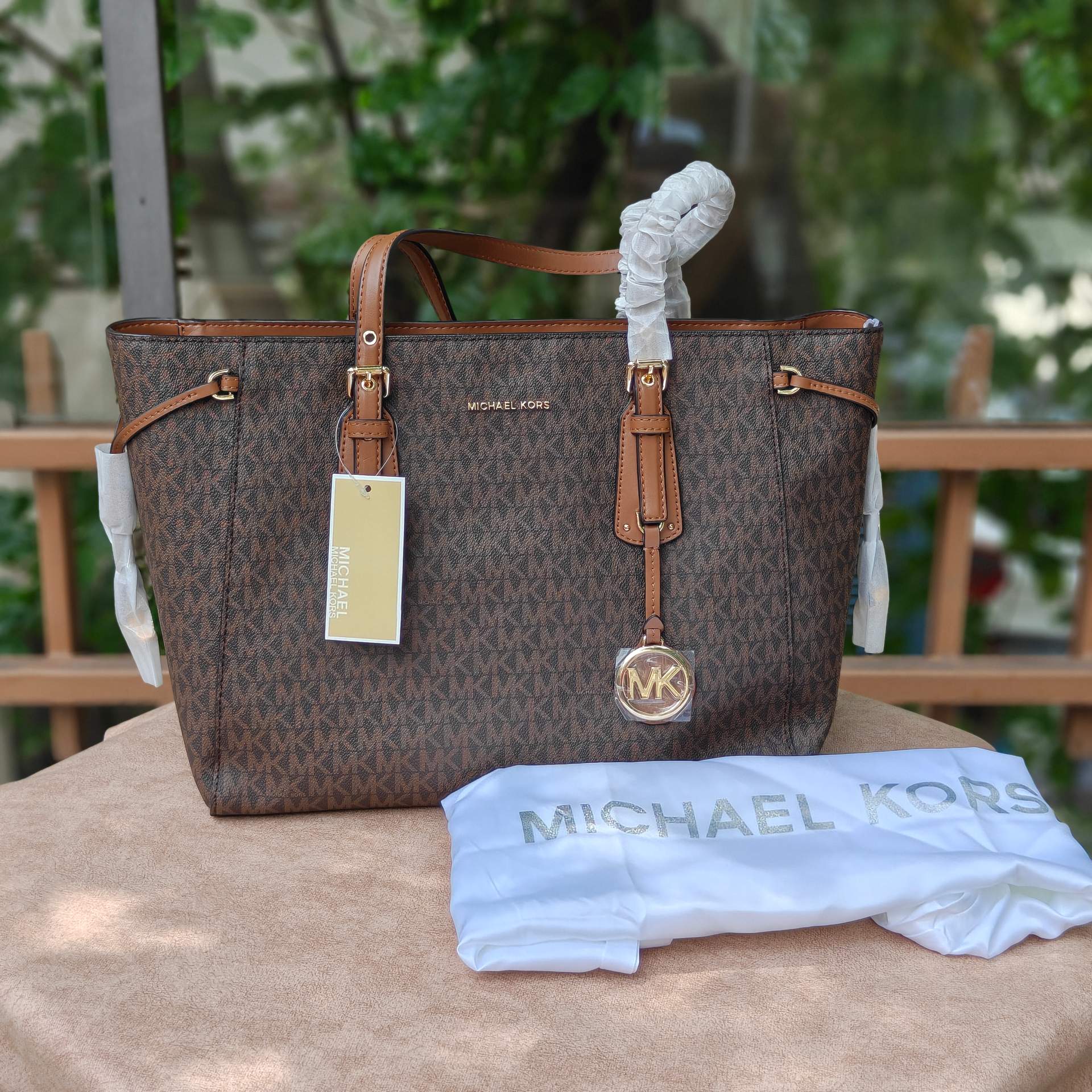 M.K Voyager tote brown monogram pattern and iconic gold-tone charm Luxury Bag